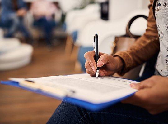 Patient in Parma Heights filling out forms for teeth whitening