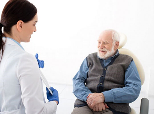 smiling older man talking to dental team member