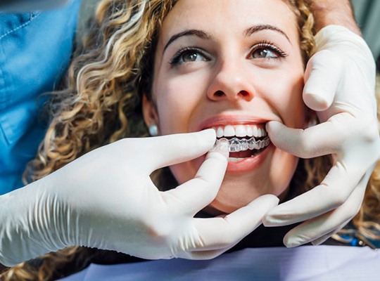 Dentist adjusting a patient’s Invisalign tray