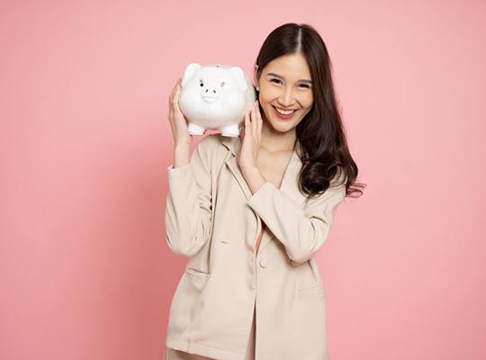 Woman holding a piggy bank and smiling