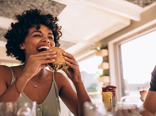 Woman smiling while eating lunch at restaurant