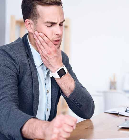 Man sitting at desk with discomfort in jaw