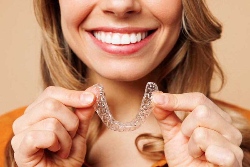 Patient smiling with their Invisalign tray